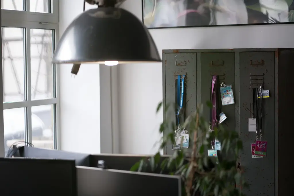 Industrielampe über einem alten Spind mit Backstage-Pässen im Büro der Agentur Ausdruckslos