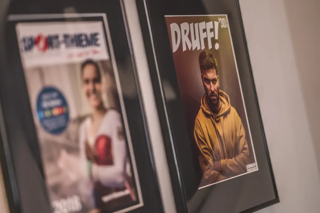 Gerahmte Magazincover an der Wand im Büro der Agentur Ausdruckslos