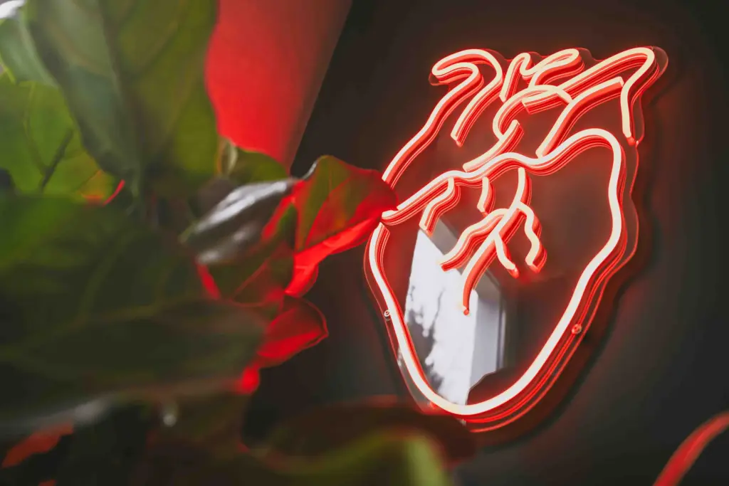 Rotes Neon-Herz an der Wand im Büro der Agentur Ausdruckslos