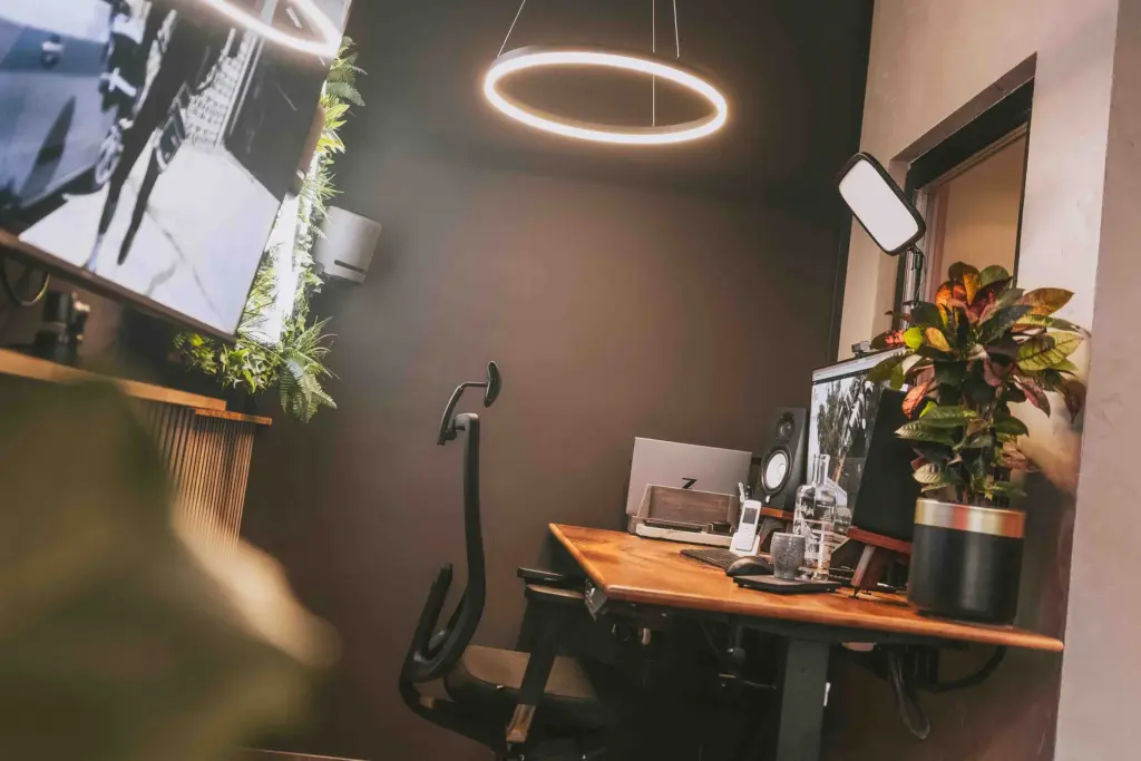 Schreibtisch mit Bildschirm, Ringleuchte und Pflanzen im Büro der Agentur Ausdruckslos