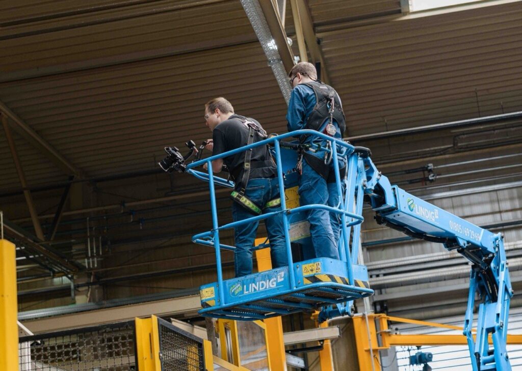 Kamerateam der Agentur Ausdruckslos auf einer Hebebühne beim Dreh in einer Werkhalle